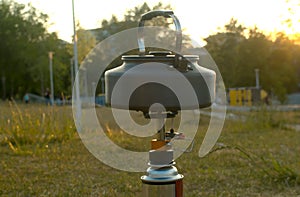 Kettle heating on a camp stove in a park
