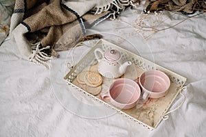 Kettle with tea and cups on a tray. Breakfast at home in bed, coziness