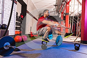 Kettlebell man pistol squat balance at gym photo