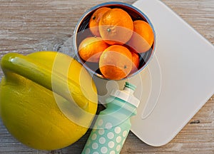 Kettlebell, tangerines, scales and bottle of water