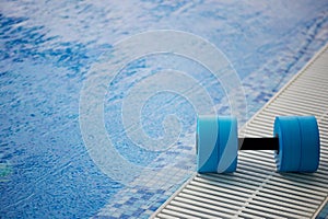 The kettlebell for water aerobics lies on the edge of the pool. Near the water.Exercise, swimming and a healthy