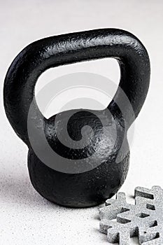 Kettlebell winter fitness, black kettlebell on a white background with silver sparkles and a silver snowflake