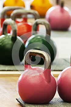 Kettlebells of various colors and weights on gym floor