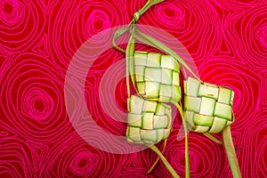 Ketupat Pouches on a red patterned background.