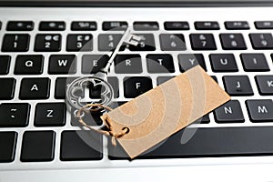 Key with blank tag on laptop keyboard, closeup. Keyword concept