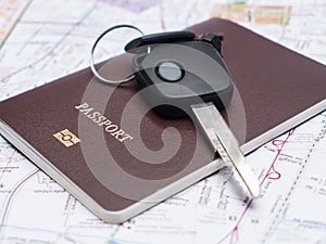 Key from the car and passport on map.