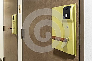 Key card door opener on brown wood door