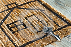 key on doormat with house outline drawing