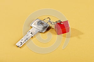 Key and fob with red house on yellow background