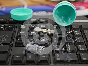 A key gets dirty and sticky, as it is played by a little baby girl to scoop oilment out and paint it on daddy`s computer keyboard