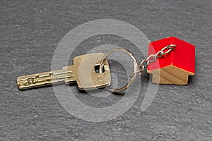 Key with house shaped key chain on slate