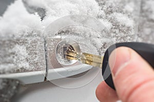 Key inserted into the lock of frozen car door