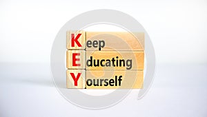 KEY, keep educating yourself symbol. Wooden blocks with words `KEY, keep educating yourself`. Beautiful white background, copy