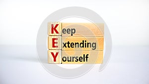 KEY, keep extending yourself symbol. Wooden blocks with words `KEY, keep extending yourself`. Beautiful white background, copy