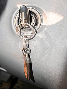 Key with a key fob in the ignition lock of a passenger car.