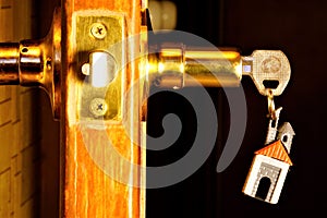 Key with a keychain in the form of a house in the door lock. The key tool to open locks for clues, solutions, understanding of