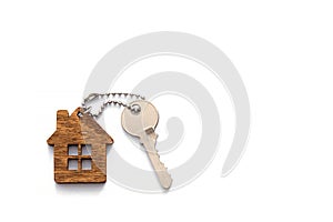 A key with a keychain in the form of a house on a white background. The concept of buying, renting, and insuring housing