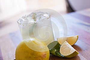 Key lime margarita garnished with fresh lime in a glass bar table
