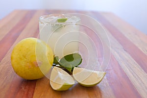 Key lime margarita garnished with fresh lime in a glass bar table