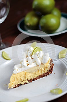 Key Lime Pie on wood table with limes