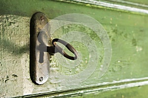 Key and lock on the green wooden door