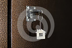 A key in a lock with house icon. process of opening the front door to the apartment.