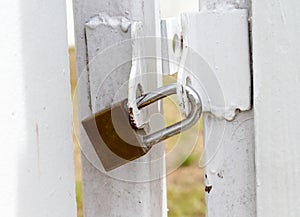 Key lock at white fence for protection asset.