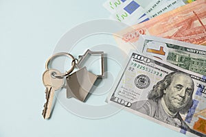 Key for a new house or apartment and currency paper banknotes euro dollars bills.