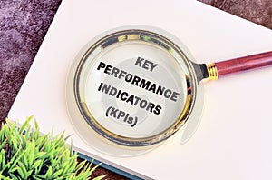 KEY PERFORMANCE INDICATORS (KPIs) in a notebook on a purple background through a photo