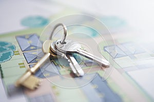 Key ring with three keys lying on architectural blueprint close-up