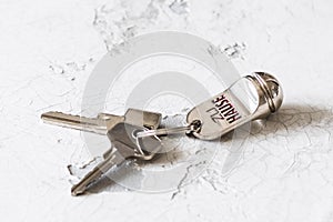 Key ring with two keys and tag with German text Zu Hause (translation: at home) on a white background