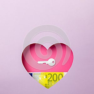 The key to the door and the two hundred euro banknote are in a pink heart on a purple background. Minimal concept of money, love