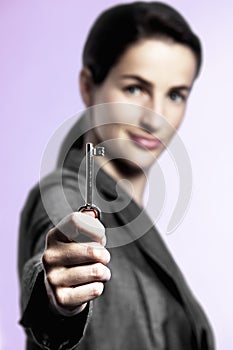 Key to success, business woman holding key upright