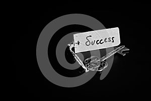 Key to Success concept - Old key with success tag isolated on black background
