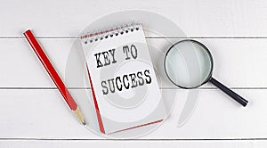 KEY TO SUCCESS text on notebook on white wooden background , business concept