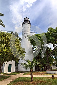 Key West Lighthouse with a Poinciana tree out front overlooks Old Town Key West