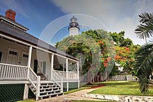 Key West Lighthouse with a Poinciana tree out front overlooks Old Town Key West