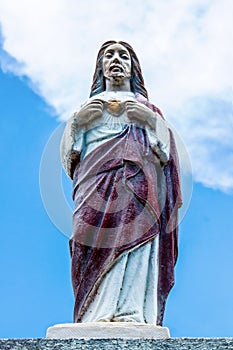 Key West USA - Looking up at Sacred Heart Jesus statue with blue sky and cloud behind