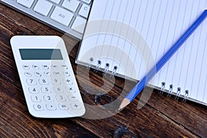 Keyboard computer with notepad and calculator on table
