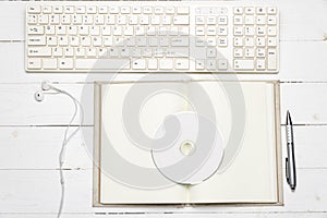 Keyboard computer with open notebook and dvd disc