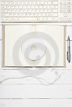 Keyboard computer with open notebook and dvd disc