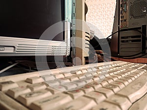 Keyboard with dirty keys, next to old LCD monitors and computers