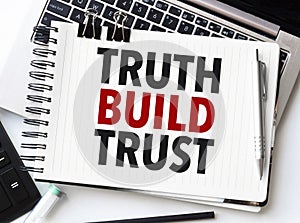 Keyboard of laptop, calculator, pencil and notepad with text truth build trust on the white background