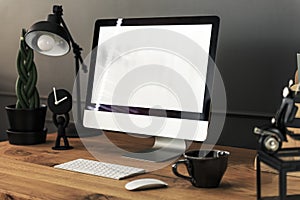 Keyboard, mouse and desktop computer on wooden desk with lamp in