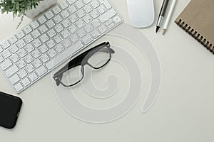 Keyboard mouse glasses pen pencil notepad phone on white background