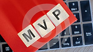 on keyboard notebook cubes with the inscription - MVP, red paper on background