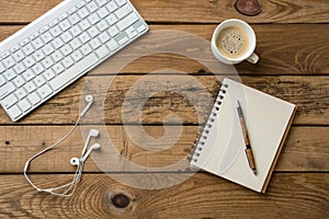 Keyboard, notepad, earphones on rustic wooden table photo