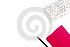 Keyboard, pink diary and a black pen on a white background. Minimal feminine business concept. Flat lay.