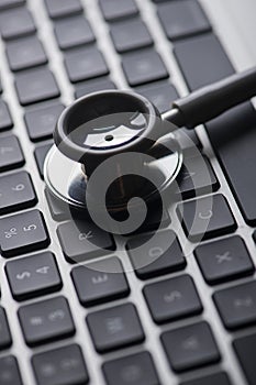 Keyboard with stethoscope low key photo concept