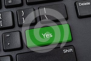 Keyboard with Yes button. Green key with Yes words on a black desktop computer keyboard. Confirm, verify, agree the terms and and